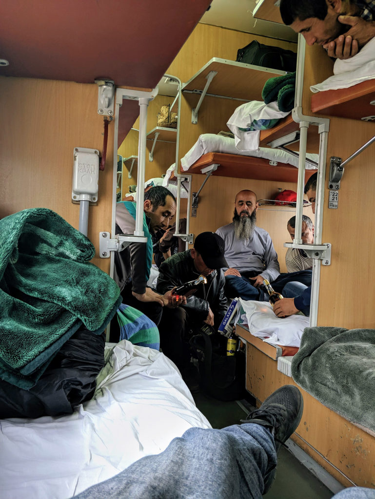 Seller on the train showing his booze and phone accessories