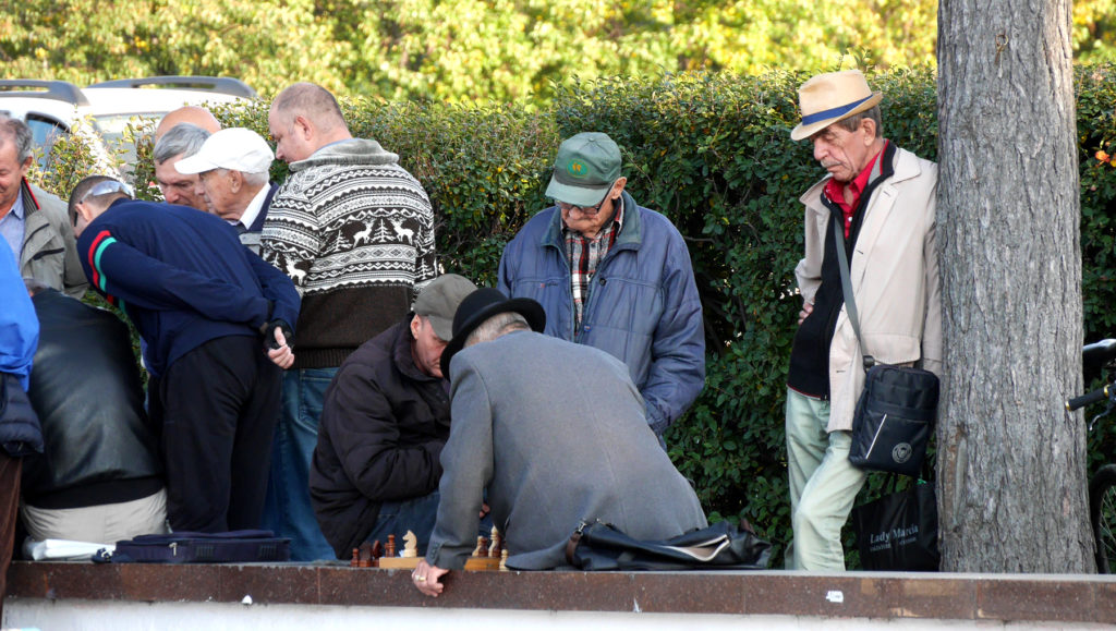 Männer beim Schachspielen nahe des Flusses