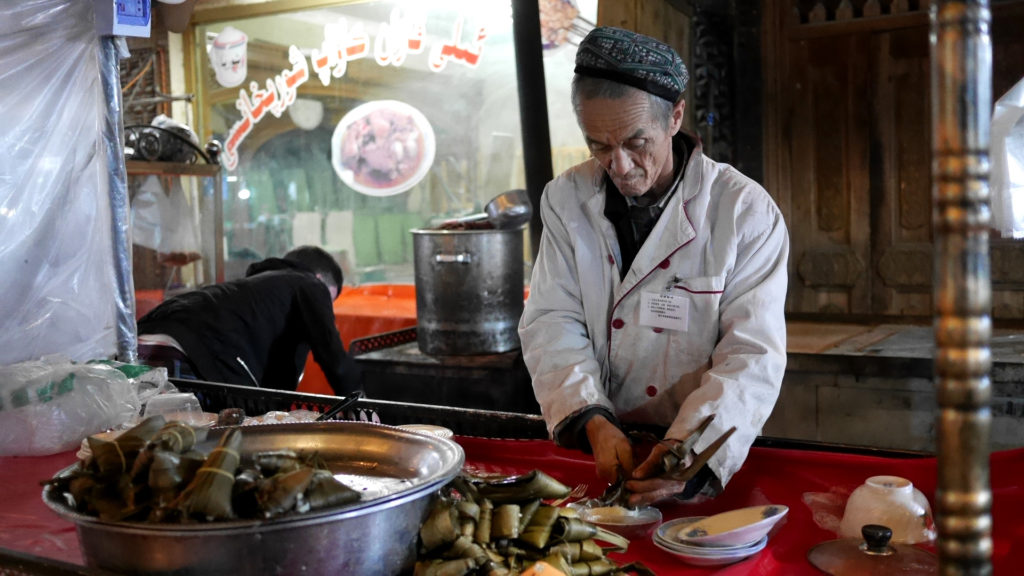 Old man preparing us a desert out of sticky rice, yogurt and honey