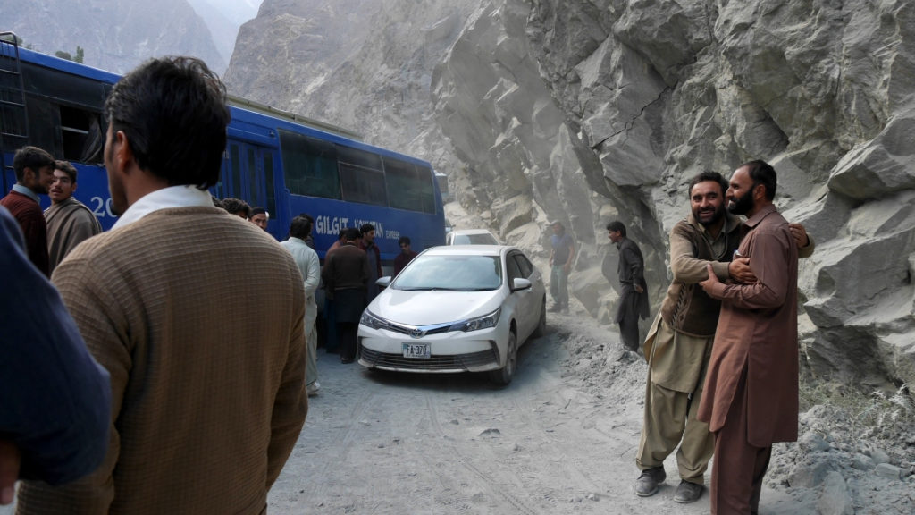 The men (including Seri) worked together to dig a way for the small cars to pass