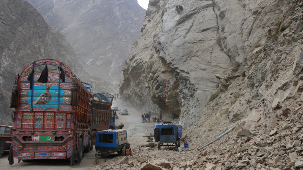 The road was temporarily blocked because of blastings ahead. Up in the picture you can see the two workers drilling the rock while we were stuck under it.