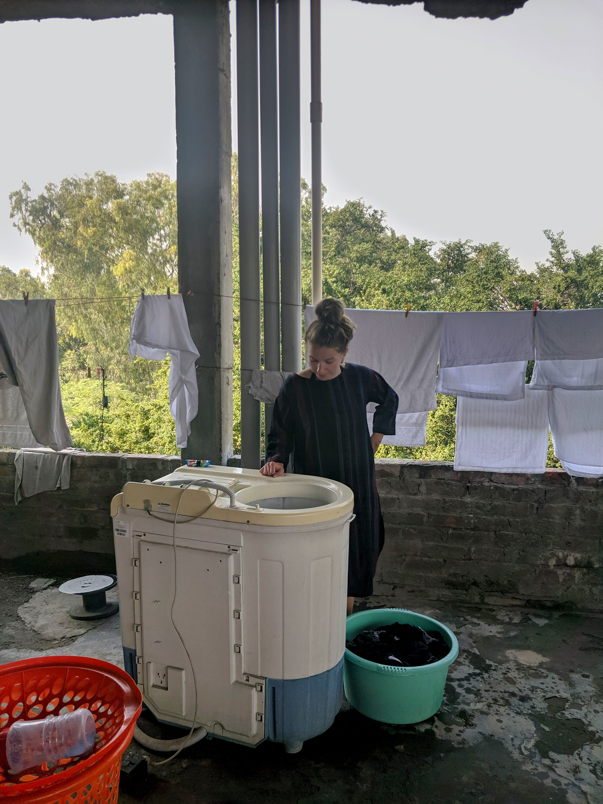 Johanna learning to use the Indian semi-automatic washing machine