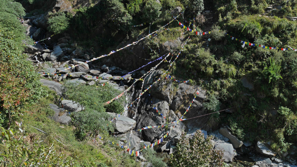 Prayer flags hanging over the stream