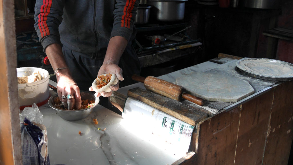 Rana making a potato paratha for us. First you fill it...