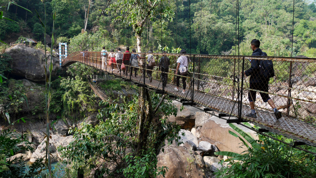 A group of young Indian tourists crossing a bridge just before Nongriat