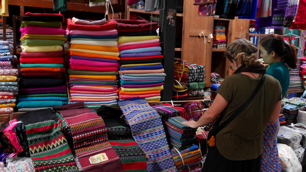 Johanna trying to make the tough choice between all the possible colors and patterns of the longyi fabrics