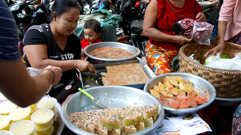 Burmese sweets. The white paste on the faces of the baker and her child is called thanaka and it's widely used in Myanmar