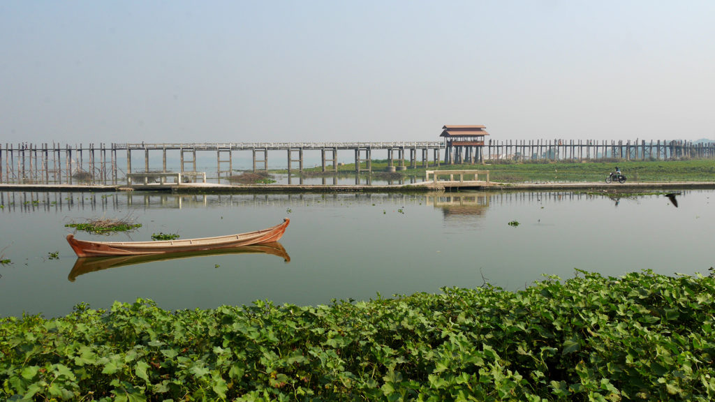 Seri riding the Enfield next to the U Bein Bridge