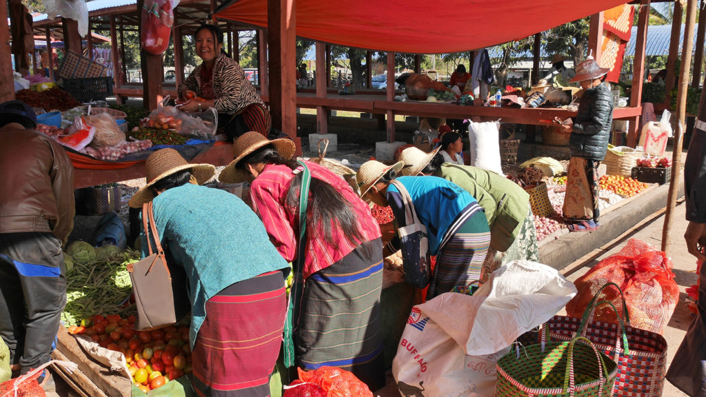 Women wearing longyis and straw hats